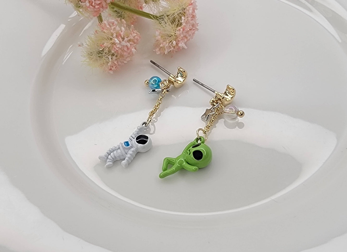 ASTRONAUT AND ALIEN UNBALANCE DANGLE EARRINGS.
