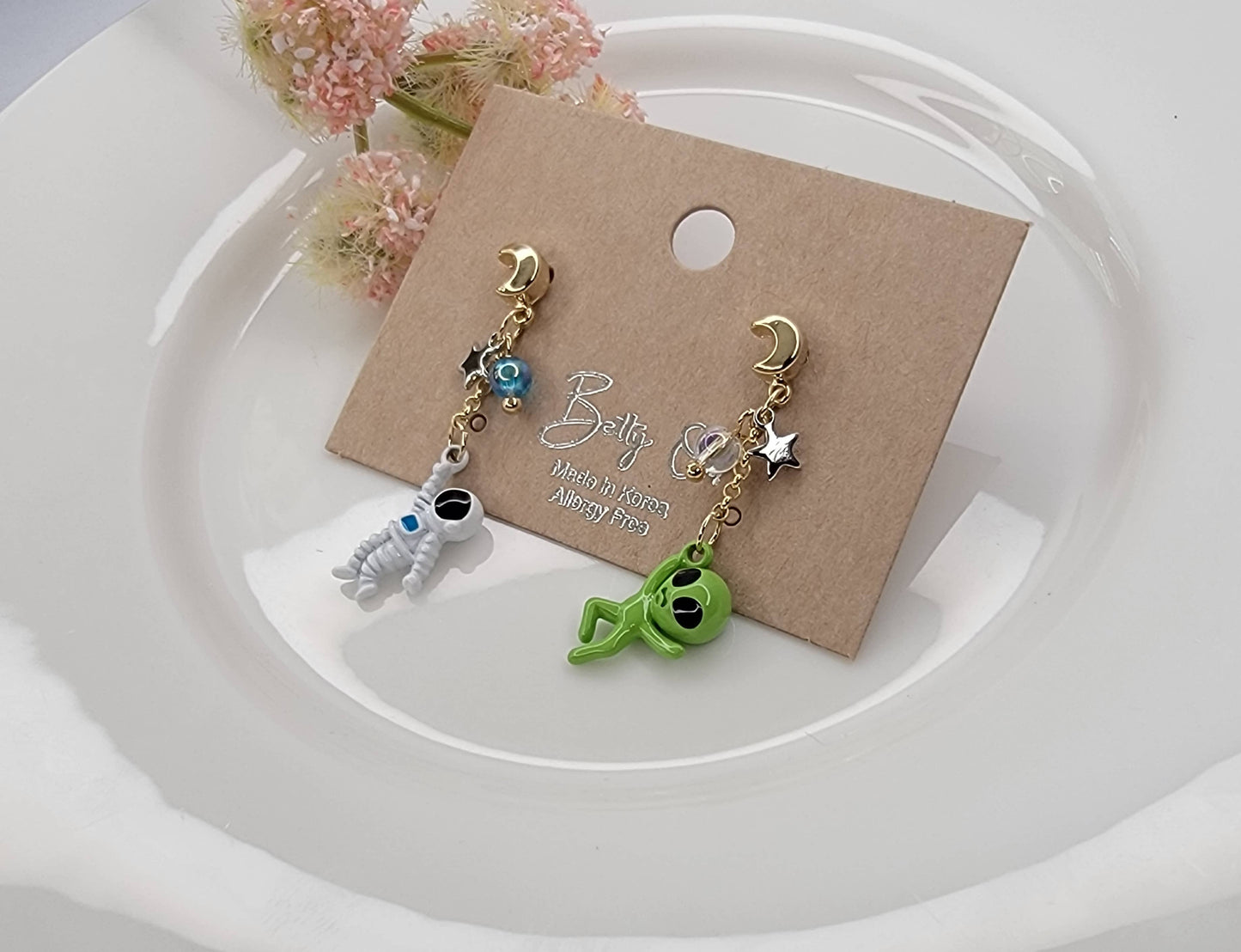 ASTRONAUT AND ALIEN UNBALANCE DANGLE EARRINGS.
