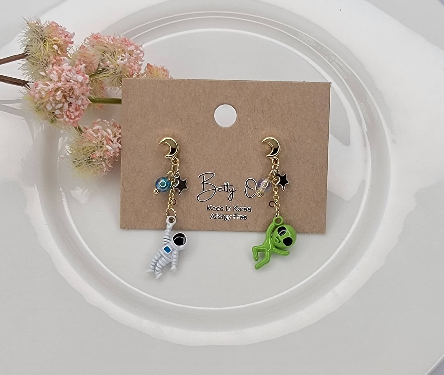 ASTRONAUT AND ALIEN UNBALANCE DANGLE EARRINGS.