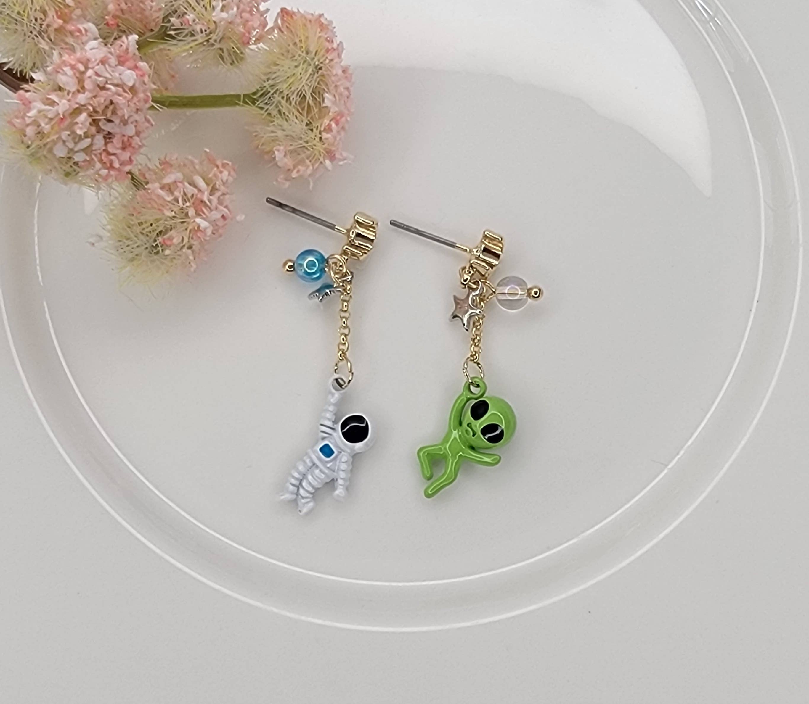 ASTRONAUT AND ALIEN UNBALANCE DANGLE EARRINGS.