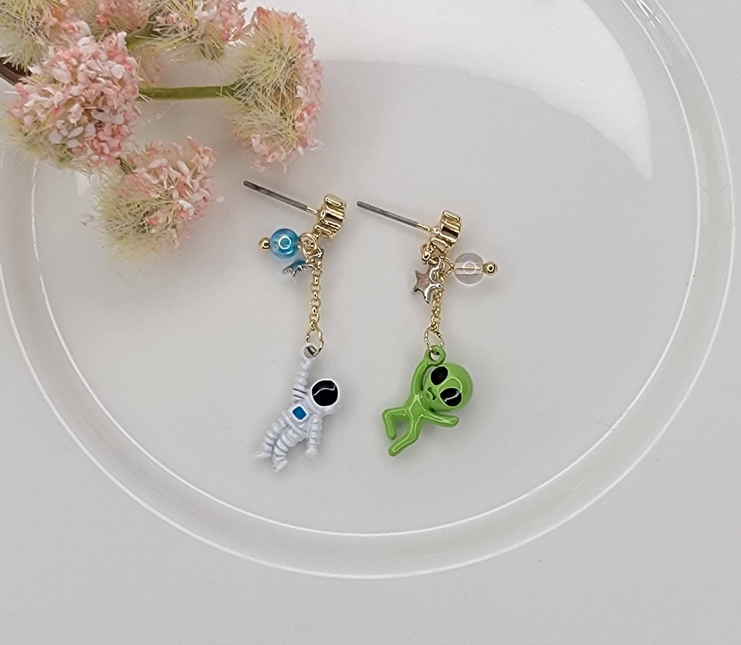 ASTRONAUT AND ALIEN UNBALANCE DANGLE EARRINGS.
