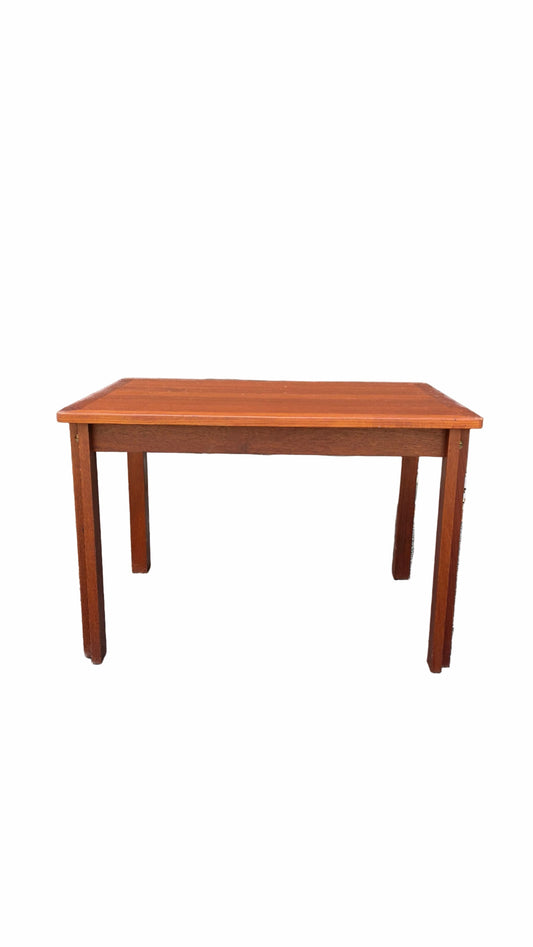 A rectangular wooden table with a warm reddish-brown finish and four legs, shown against a plain white background.